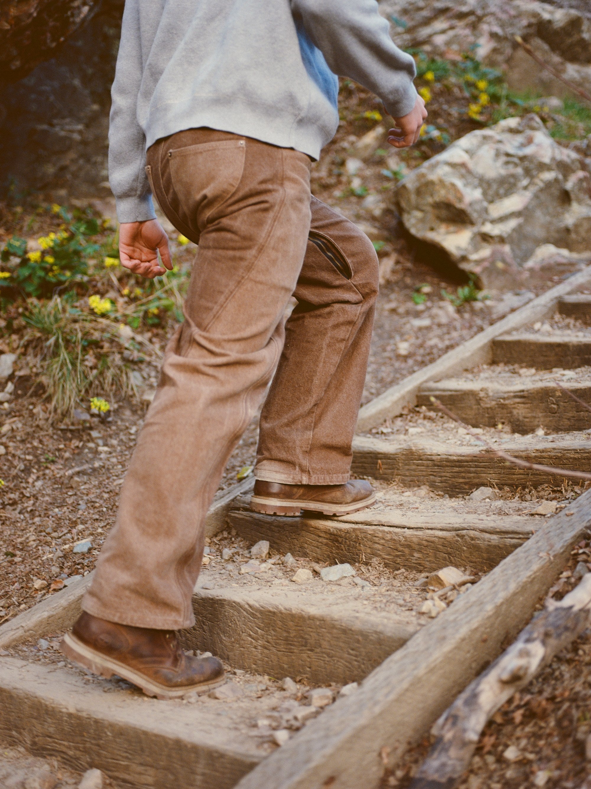 Person climbing outdoor stone steps in the Centenarian Functional Jeans